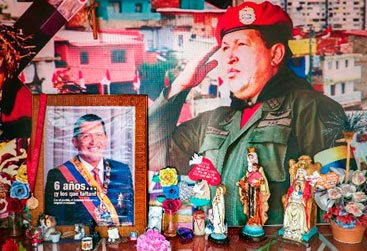 A devoção ao líder bolivariano, promotor desde 1999 de um modelo socialista baseado na redistribuição dos recursos petroleiros junto às classes pobres, permanece na iconografia do chavismo, com murais, cartazes e fotos de seu rosto espalhados pela capital. Foto: Federico Parra/AFP Photo/