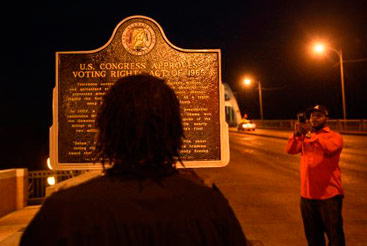 Homem lê uma placa na Ponte Edmund Pettus, em Selma. Foto: Brendan Smialowski/AFP Photo() Homem lê uma placa na Ponte Edmund Pettus, em Selma. Foto: Brendan Smialowski/AFP Photo/