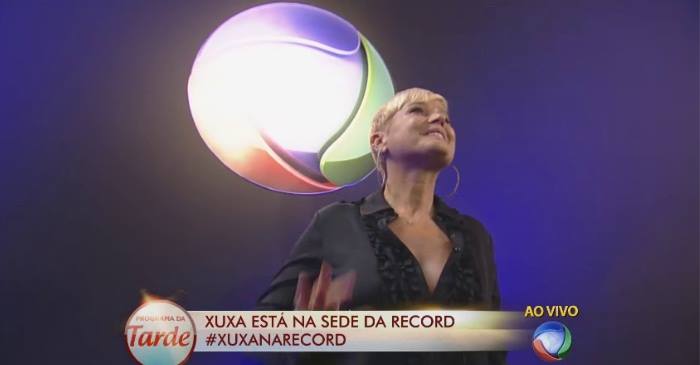 Apresentadora assinou o contrato ao lado do vice-presidente artístico e de programação da emissora. Crédito: Facebook/Reprodução() Apresentadora assinou o contrato ao lado do vice-presidente artístico e de programação da emissora. Crédito: Facebook/Reprodução/