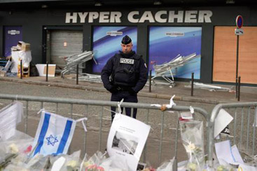 A loja Hyper Cacher, cen&aacute;rio de uma violenta tomada de ref&eacute;ns em 9 de janeiro, vigiada por policial em 21 de janeiro de 2015, em Paris. Foto: Eric Feferberg/AFP Photo/