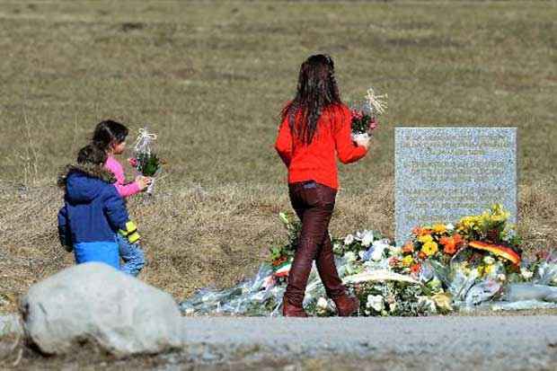 Pessoas prestam homenagem &agrave;s v&iacute;timas do acidente com o Airbus A320 da Germanwings em memorial montado em Le Vernet, nos Alpes franceses, no dia 27 de mar&ccedil;o de 2015. Foto: Boris Horvat/AFP/