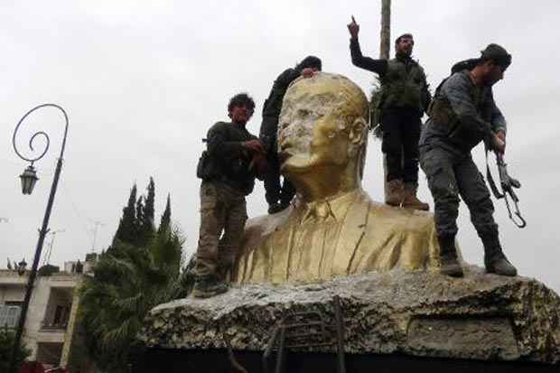 Combatentes da Frente Al-Nosra, braço sírio da Al-Qaeda, atacam estátua do falecido presidente sírio Hafez al-Assad, pai do atual presidente Bashar al-Assad, em Idleb em 28 de março. Foto: Sami Ali/AFP() Combatentes da Frente Al-Nosra, braço sírio da Al-Qaeda, atacam estátua do falecido presidente sírio Hafez al-Assad, pai do atual presidente Bashar al-Assad, em Idleb em 28 de março. Foto: Sami Ali/AFP/