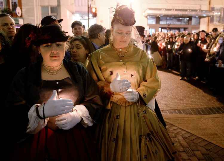 Pessoas fantasiadas participaram de uma homenagem no teatro Ford com uma vigília com velas e conferências de historiadores. Foto: Olivier Douleiry/ Getty images/ AFP/