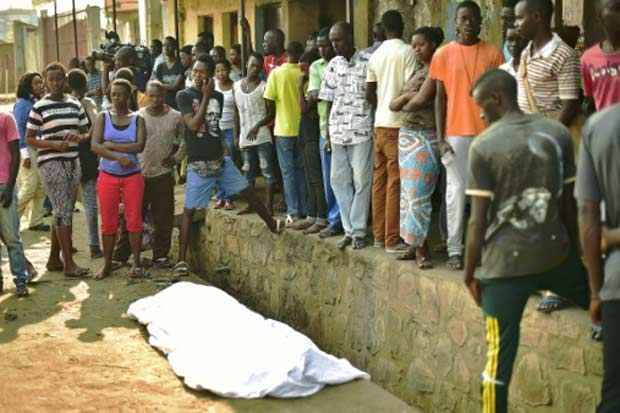 Curiosos se concentram em torno do corpo de um homem morto com um tiro em Bujumbura. Foto: Carl de Souza/AFP/ Curiosos se concentram em torno do corpo de um homem morto com um tiro em Bujumbura. Foto: Carl de Souza/AFP/