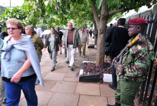 Um policial queniano fica de guarda enquanto um grupo de turistas passeia do lado de fora do Comitê Pré-Global de Empreendedorismo em Nairób, no dia 23 de julho de 2015. Foto: Simon Maina/AFP/ Um policial queniano fica de guarda enquanto um grupo de turistas passeia do lado de fora do Comitê Pré-Global de Empreendedorismo em Nairób, no dia 23 de julho de 2015. Foto: Simon Maina/AFP/