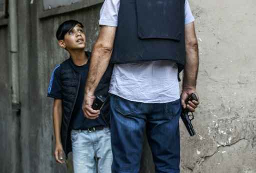 Um policial turco faz perguntas para menino curdo depois de um ataque contra agentes da polícia turca em Diyarbakir, no dia 23 de julho de 2015. Foto: Bulent Kilic/ AFP/ Um policial turco faz perguntas para menino curdo depois de um ataque contra agentes da polícia turca em Diyarbakir, no dia 23 de julho de 2015. Foto: Bulent Kilic/ AFP/