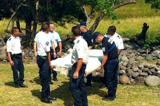 Policiais removem um pedaço de avião encontrado na ilha Reunião. Foto: Yannick Piton/AFP/