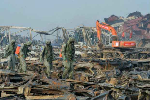 Trabalhadores em trajes especiais preparados para limpar o local onde ocorreram as mortíferas explosões em Tianjin. Foto: AFP Str/ Trabalhadores em trajes especiais preparados para limpar o local onde ocorreram as mortíferas explosões em Tianjin. Foto: AFP Str/
