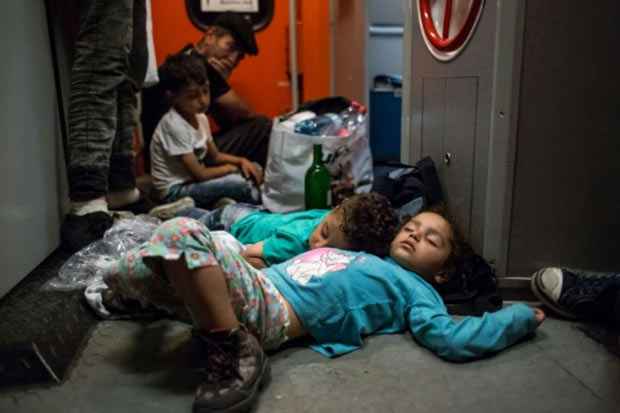 Crianças imigrantes dormem no chão de trem que viajava de Budapeste para Munique em 31 de agosto. Foto: Vladimir Simicek/AFP/ Crianças imigrantes dormem no chão de trem que viajava de Budapeste para Munique em 31 de agosto. Foto: Vladimir Simicek/AFP/