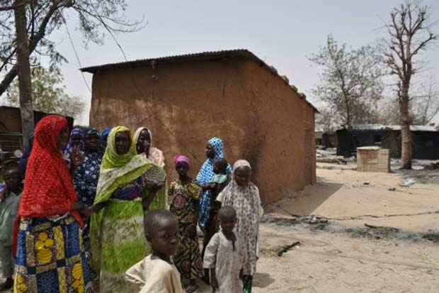 Mulheres e crianças em frente as suas casas incendiadas pelo Boko Haram em 26 de maio de 2015 em Gubio, no estado nigeriano de Borno. Foto: AFP/Arquivos/