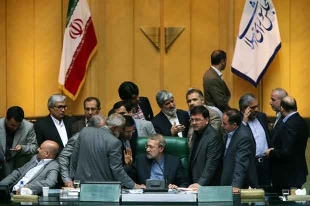 O porta-voz do Parlamento iraniano, Ali Larijani (centro), conversa com deputado durante uma sess&atilde;o em 11 de outubro. Foto: STR/AFP/