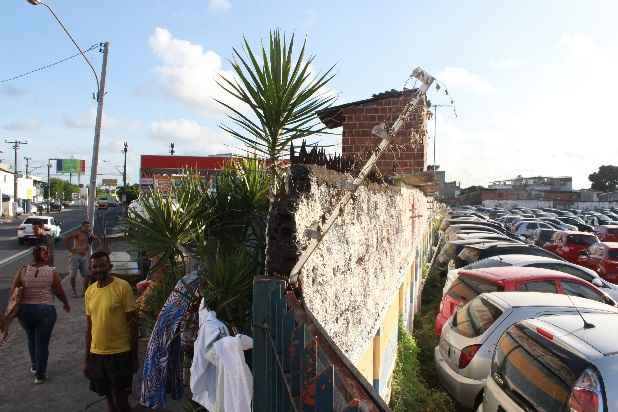 Uma cerca elétrica separa a comunidade de um pátio de estacionamento de carros. Há grandes terrenos usados como estacionamentos de veículos próximo à área onde cerca de 200 famílias habitam precariamente. Foto: Brenda Alcantara/Esp. DP 