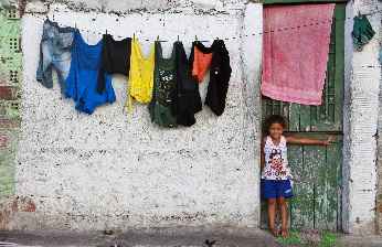 Em dias de alta do canal, parte do lixo fica submerso e algumas crianças nadam no local. Na foto, Myllena Bianca, moradora da Escorregou Tá Dentro. Foto: Brenda Alcantara/Esp. DP 