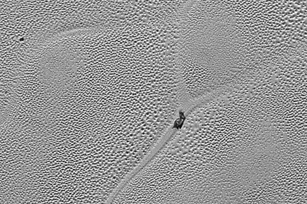 Na imagem aparece um objeto semelhante ao um caracol andando na esburacada superfície do planeta anão. Foto: Nasa/Jhuapl/SwRI