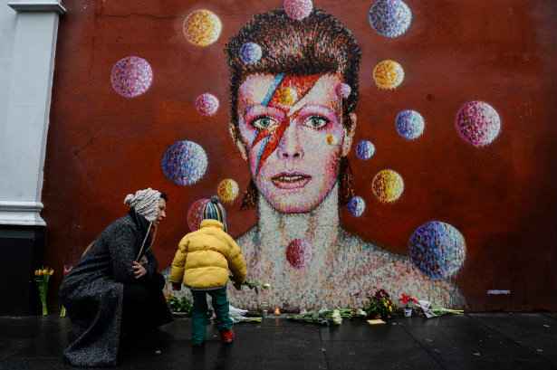 Homenagens são deixados sob um mural de cantor britânico David Bowie, pintado pelo artista australiano, em Londres. Foto: Chris Ratcliffe/AFP/ Homenagens são deixados sob um mural de cantor britânico David Bowie, pintado pelo artista australiano, em Londres. Foto: Chris Ratcliffe/AFP/