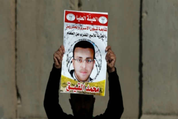 Palestino mostra um retrato de Mohammed al-Qiq, na Cisjordânia. Foto: Abbas Momani/AFP/ Palestino mostra um retrato de Mohammed al-Qiq, na Cisjordânia. Foto: Abbas Momani/AFP/