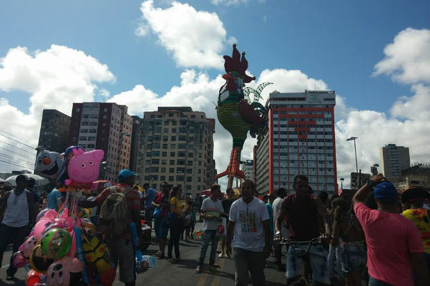 Pedestres param para um "selfie" e comerciantes aproveitam a alegoria famosa para vender seus produtos. Foto: Mariana Fabrício/ DP/