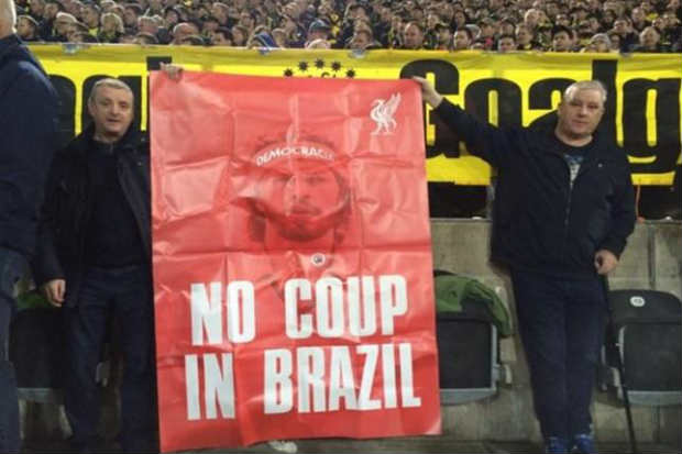 Em partida válida pela Liga Europa, dois torcedores do Liverpool estamparam uma bandeira vermelha com os dizeres %u201Cno coup in Brazil%u201D (sem golpe no Brasil). Foto: Reprodução/Twitter/ Em partida válida pela Liga Europa, dois torcedores do Liverpool estamparam uma bandeira vermelha com os dizeres %u201Cno coup in Brazil%u201D (sem golpe no Brasil). Foto: Reprodução/Twitter/