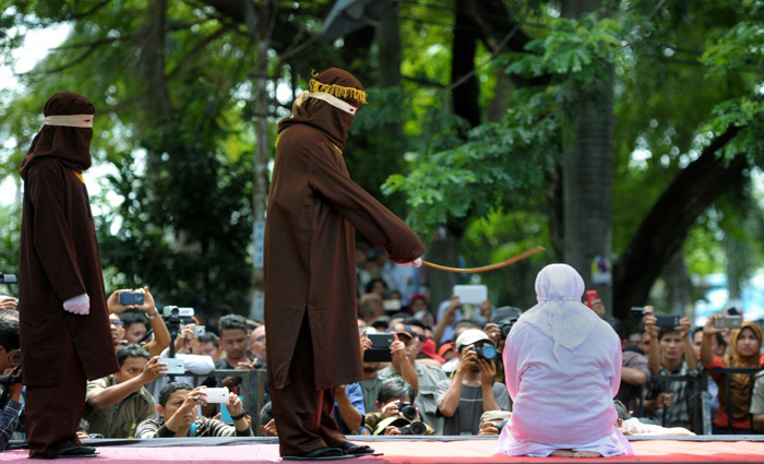 Religioso bate 100 vezes em mulher (D) por ter feito sexo fora do casamento, o que vai de encontro &agrave; lei Sharia, em Aceh, no dia 28 de novembro de 2016. Foto: Chaideer Mahyuddin/AFP/