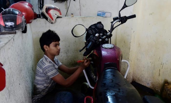 Menino de 13 anos trabalha em uma garagem, em Daca. Foto: Munir Uz Zaman/AFP/ Menino de 13 anos trabalha em uma garagem, em Daca. Foto: Munir Uz Zaman/AFP/