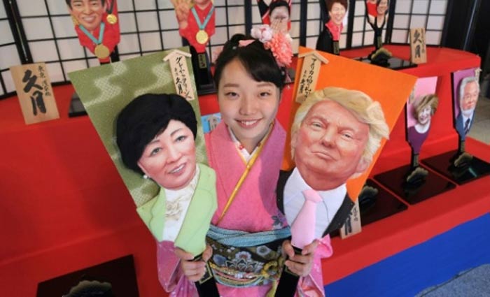 Megumi Kondo, funcionária da Kyugetsu, mostra raquetes com imagens de Trump e da governadora de Tóquio, Yuriko Koike. Foto: Kazuhiro Nogi/AFP/ Megumi Kondo, funcionária da Kyugetsu, mostra raquetes com imagens de Trump e da governadora de Tóquio, Yuriko Koike. Foto: Kazuhiro Nogi/AFP/