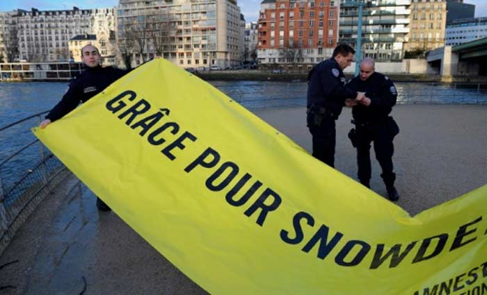 Policiais franceses retiram banner que pede por 'Perd&atilde;o a Snowden', colocado em r&eacute;plica da Est&aacute;tua da Liberdade em Paris, no dia 13 de janeiro de 2017. Foto: Eric Feferberg/AFP/