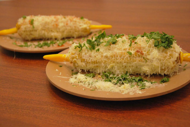 Milho Cordel (espiga cozida coberta com cream cheese, raspas de parmesão, coentro e páprica defumada), pela chef Miau Caldas. Foto: Cordel Cafés/Divulgação