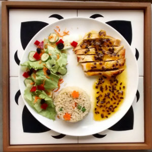 Frango grelhado com molho reduzido de maracujá com as guarnições de arroz integral à grega e a salada do dia. Foto: Dom Sain/Divulgação