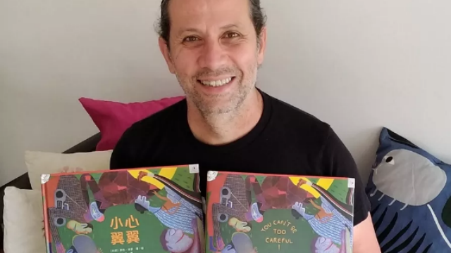 Roger com as versões chinesa e norte-americana de Todo Cuidado É Pouco. Foto: Centro de Leitura Quindim/Divulgação/ Roger com as versões chinesa e norte-americana de Todo Cuidado É Pouco. Foto: Centro de Leitura Quindim/Divulgação/