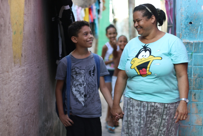 A falta de uma faixa de pedestres tira a liberdade de Isaias Cardoso, que só sai com a mãe, Jaqueline Conceição. Foto: Gabriel Melo/Esp. DP.