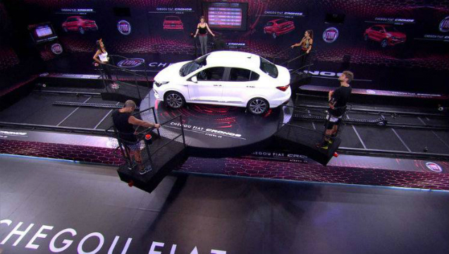 Na prova Giro Maluco, cada brother deve ficar em pé na plataforma em volta de um carro. Foto: Globo/Reprodução/