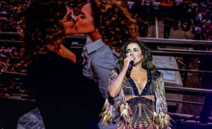 Daniela Mercury durante apresentação no Milkshake Festival, em São Paulo. Ao fundo, uma foto em que a cantora aparece beijando sua esposa, a jornalista Malu Verçosa. (foto: Instagram/Reprodução)/ Daniela Mercury durante apresentação no Milkshake Festival, em São Paulo. Ao fundo, uma foto em que a cantora aparece beijando sua esposa, a jornalista Malu Verçosa. (foto: Instagram/Reprodução)/