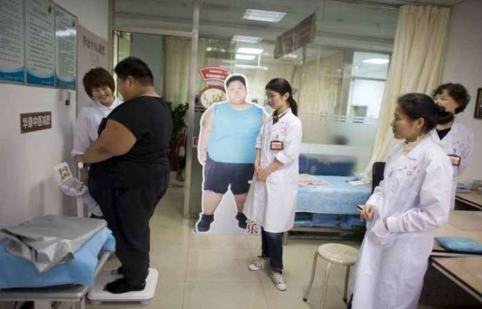 Observado por profissionais de saúde, adolescente chinês se pesa em um consultório de Pequim: demonstração de afeto é determinante para o paciente. foto: Alain Jocard/AFP - 12/4/19/ Observado por profissionais de saúde, adolescente chinês se pesa em um consultório de Pequim: demonstração de afeto é determinante para o paciente. foto: Alain Jocard/AFP - 12/4/19/