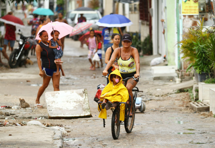 Ana usa uma bicicleta sem freio emprestada do vizinho para levar neta à creche, em Brasília Teimosa. Foto: Peu Ricardo