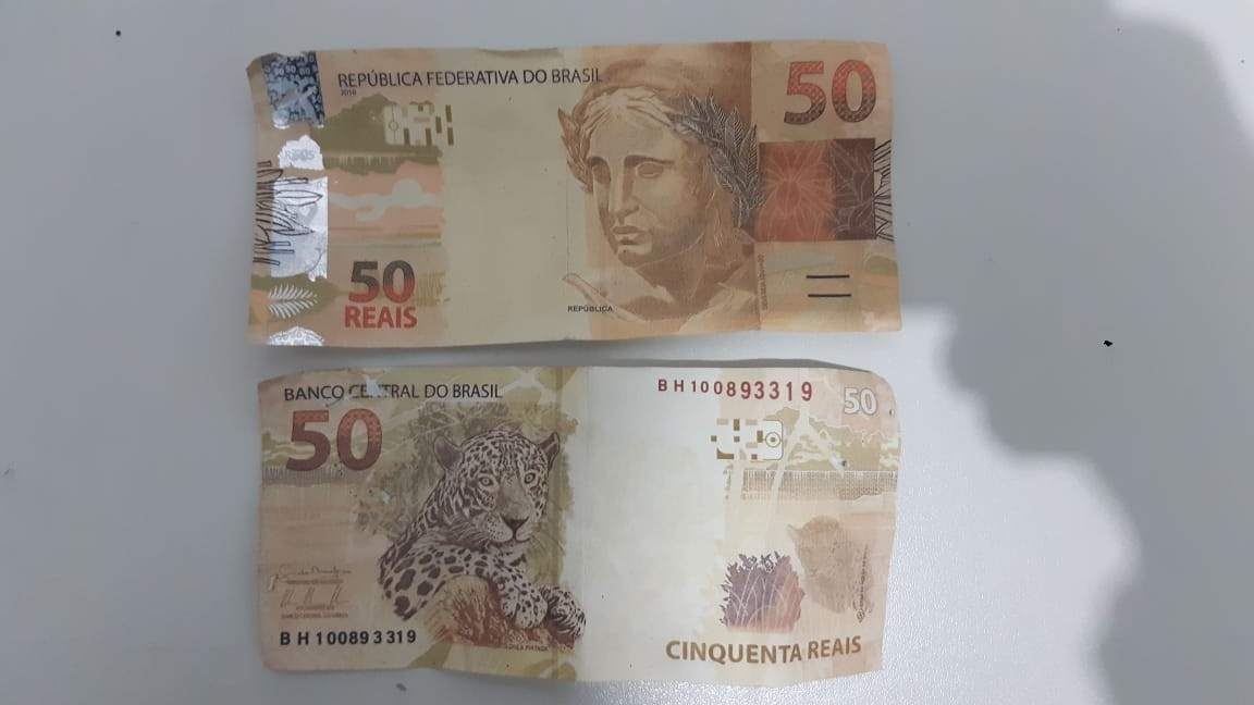 Duas cédulas falsas no valor de R$ 50 foram encontradas debaixo do banco traseiro. Crédito: PRF/Divulgação
