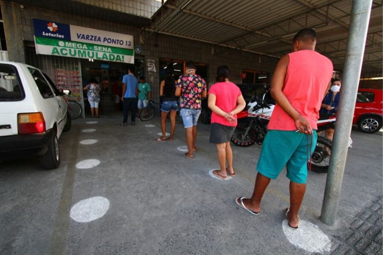Na única casa lotérica do bairro, fila pequena (sete pessoas) e demarcações para distância