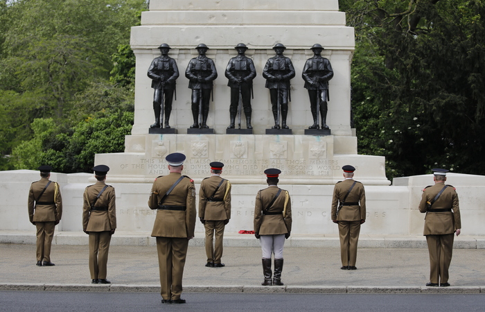 Oficiais britânicos em frente à estatuas de soldados, com 2 metros de distância, para celebrar o fim da 2ª Guerra./Foto: Tolga AKMEN / AFP