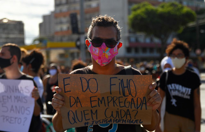 Com máscaras ou protetores faciais, manifestantes gritavam palavras de ordem e seguravam cartazes.