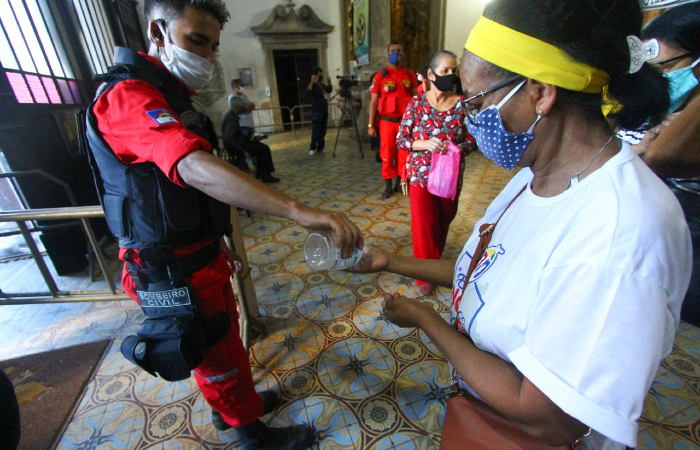 Fiéis recebem álcool em gel na entrada e saída da basílica; uso de máscara é obrigatório.
