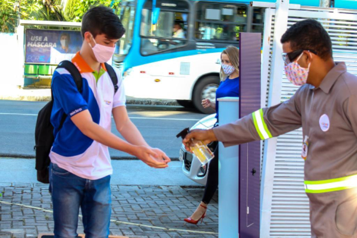 Na entrada, os estudantes limpam os pés nos tapetes sanitizantes e as mãos com álcool a 70%.