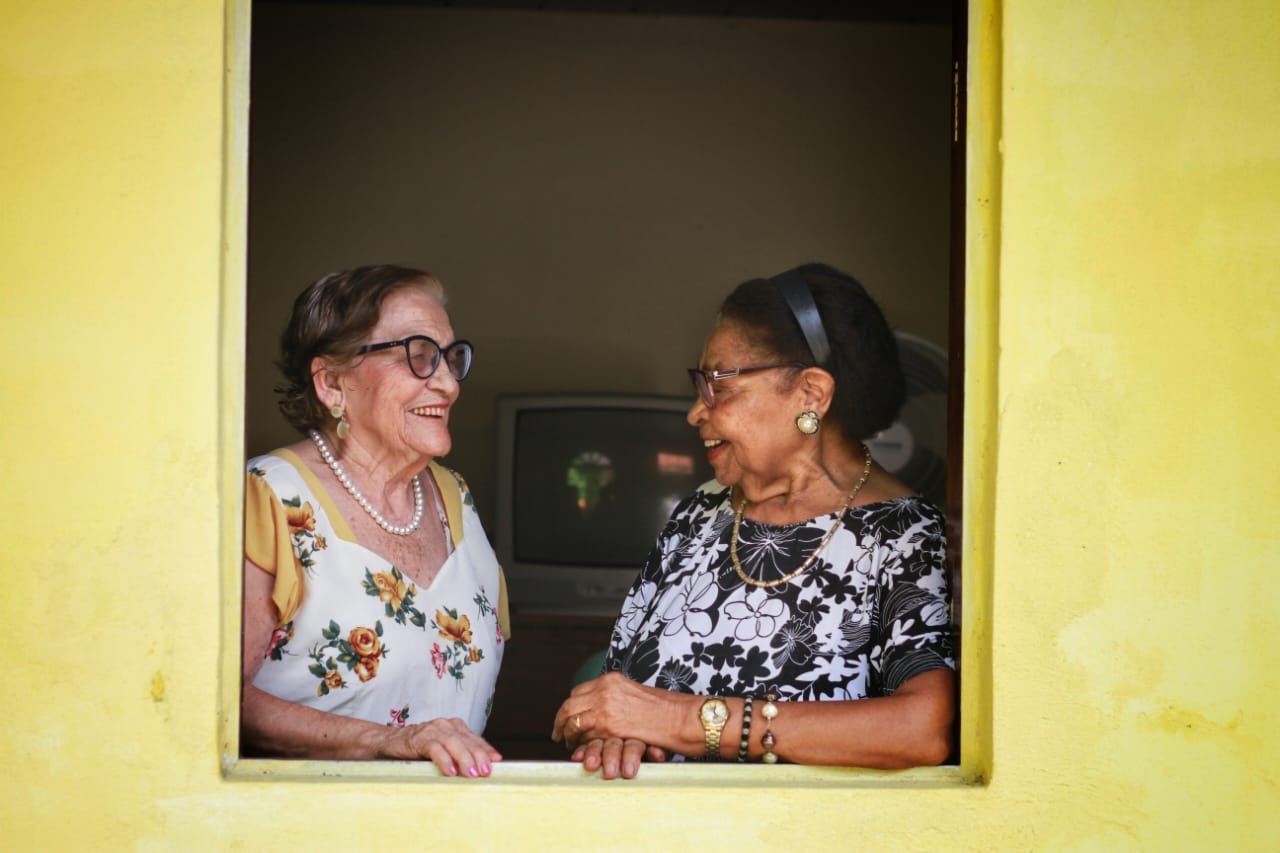 Nina e Maria da Paixão conversando na janela