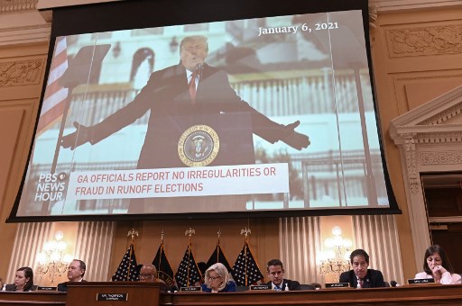 Membros da audiência do Comitê Seleto da Câmara para Investigar o Ataque de 6 de janeiro sentam-se sob uma tela que mostra o ex-presidente dos EUA, Donald Trump, dirigindo-se a uma multidão de apoiadores antes da multidão atacar o Capitólio dos EUA, durante a quarta audiência do Comitê Seleto da Câmara para Investigar o 6 de janeiro Ataque ao Capitólio dos EUA no Cannon House Office Building em Washington, DC, em 21 de junho de 2022./Foto: ROBERTO SCHMIDT / AFP