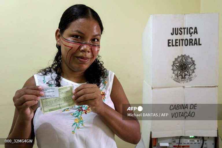 Ind&iacute;genas Sater&eacute;-Maw&eacute; desenharam em seus rostos linhas pretas e vermelhas formando a ponta de uma flecha. As setas, apontam para o "alvo" de que Lula derrote o presidente Jair Bolsonaro (PL)/Foto: MICHAEL DANTAS / AFP