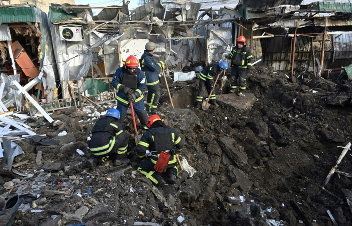 Efetivos de emergência da Ucrânia trabalham em local atingido por míssil russo em um mercado de Shevchenkove, no oblast de Kharkiv, em 9 de janeiro de 2023