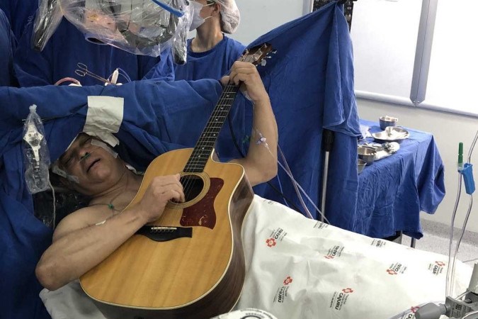 O paciente Maur&iacute;cio Stemberg durante cirurgia para retirada de tumor cerebral, tocando viol&atilde;o e cantando/Foto: Hospital Universit&aacute;rio Cajuru
