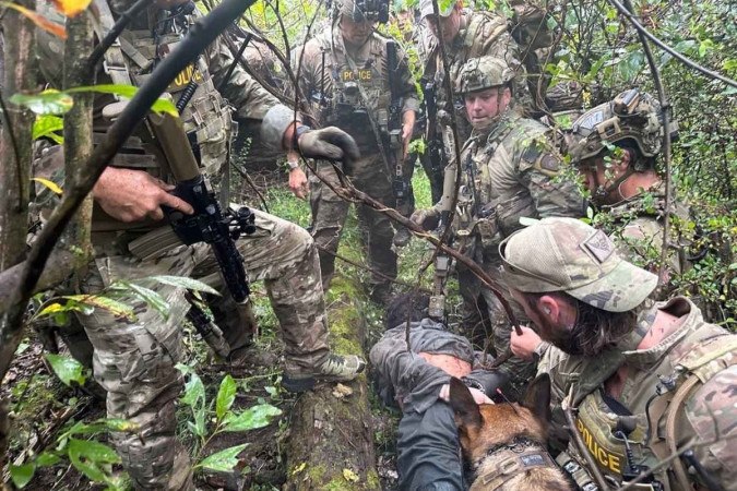 Danilo Cavalcante aparece algemado logo depois da captura, em meio à mata, com os policiais que participaram da operação