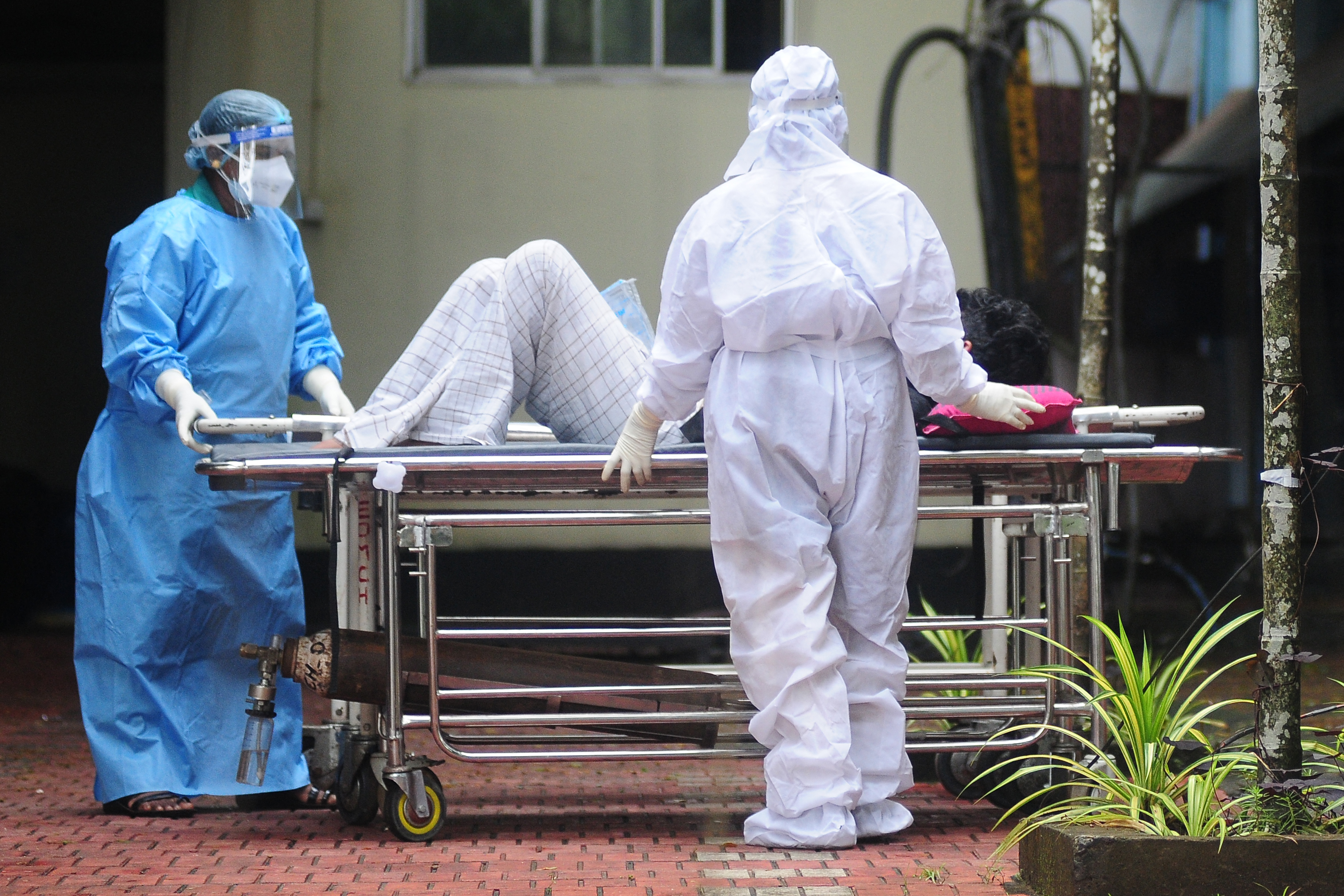 Agentes de Saúde usam trajes de proteção no transporte de um homem com sintomas do vírus Nipah no sul da Índia./AFP Agentes de Saúde usam trajes de proteção no transporte de um homem com sintomas do vírus Nipah no sul da Índia./AFP