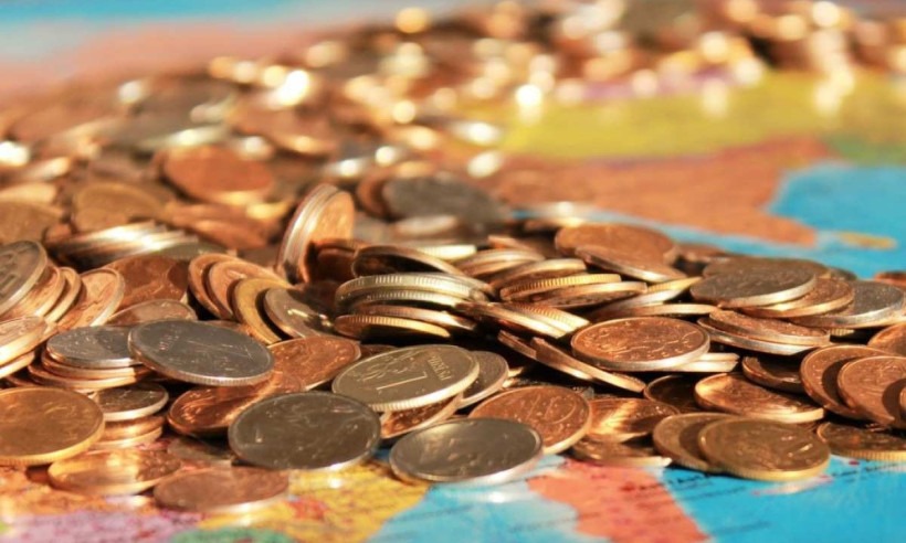 Moedas sobre mapa-mundi/foto: PxHere