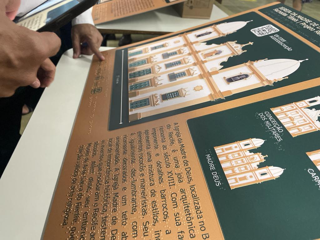 São painéis táteis contendo informações em Braille, letras ampliadas, pictolibras (sinais em Libras) e audiodescrição por meio de QR Codes.