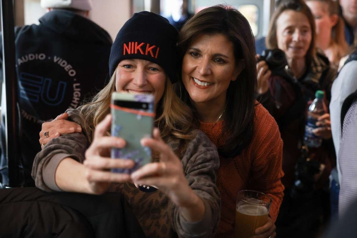 Nikki Haley (D), ex-embaixadora dos EUA na ONU e candidata republicana, faz selfie com eleitora em Concord, New Hampshire